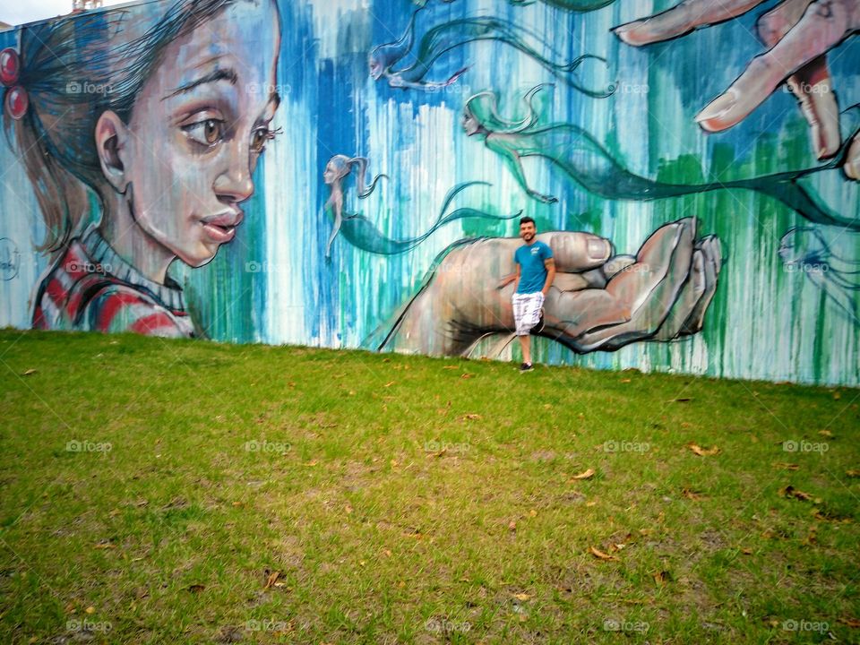 Young man standing near graffiti wall