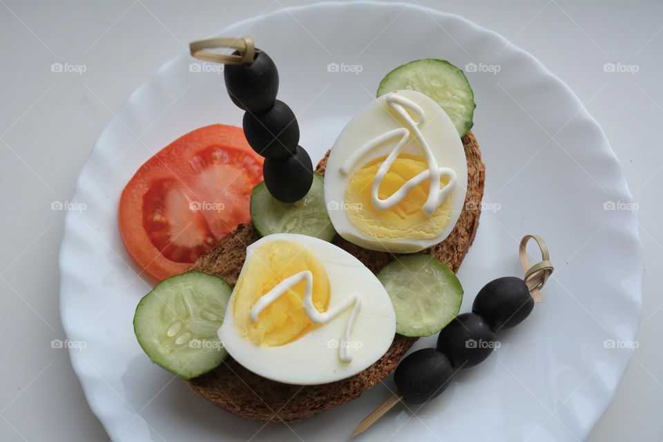 sandwiches with eggs and vegetables on a plate