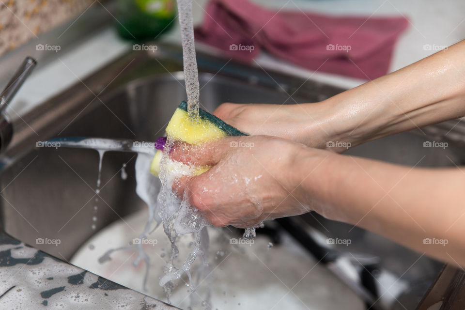 Person washing knife in kitchen