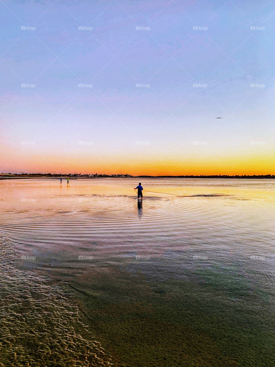 Lone fisherman at sunset