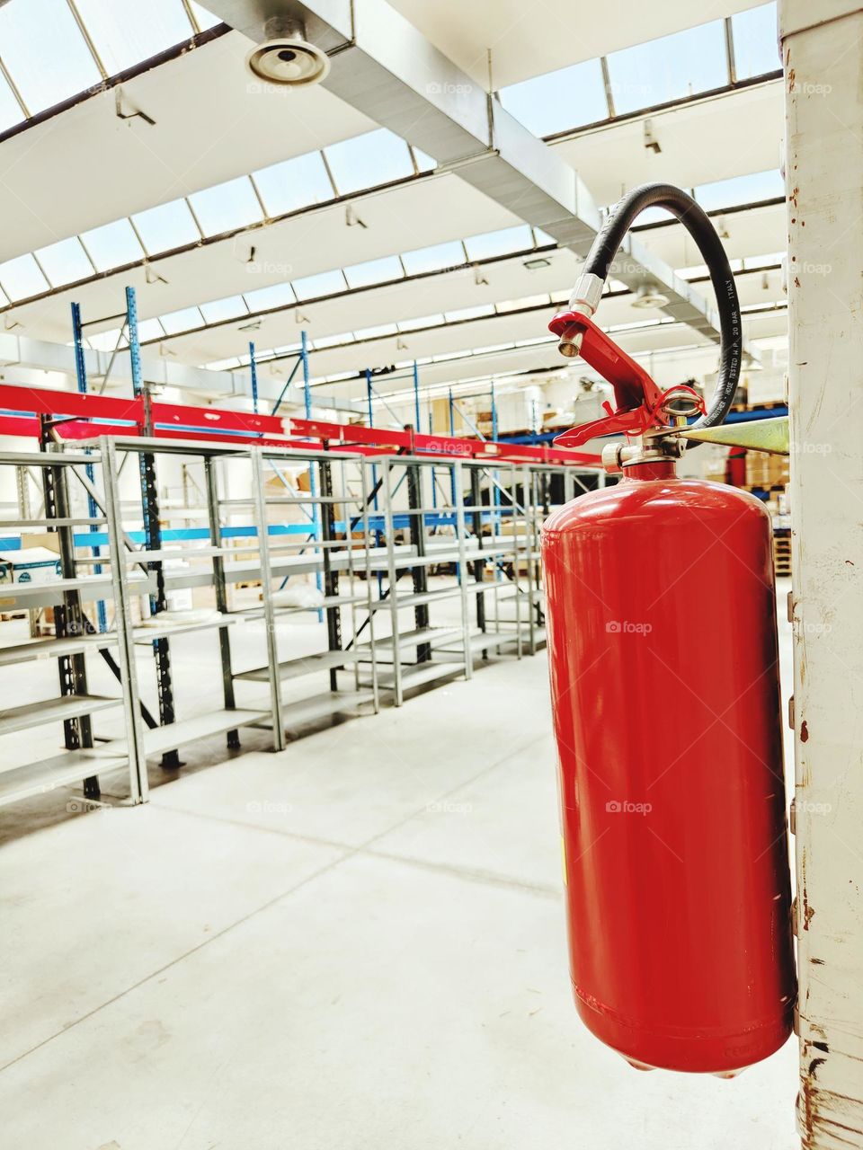 fire extinguisher in the foreground in a warehouse