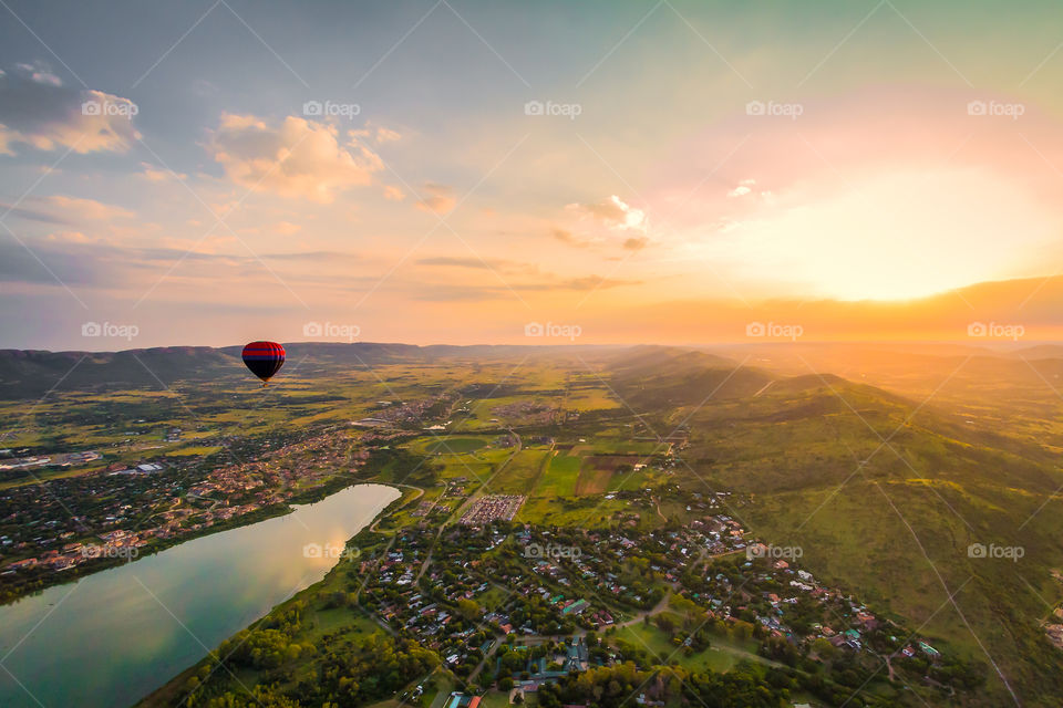 Sunrise over hot air balloon and valley below