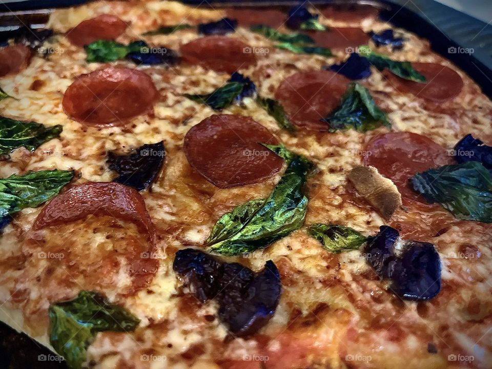 Homemade pizza , black olives basil pepperoni 