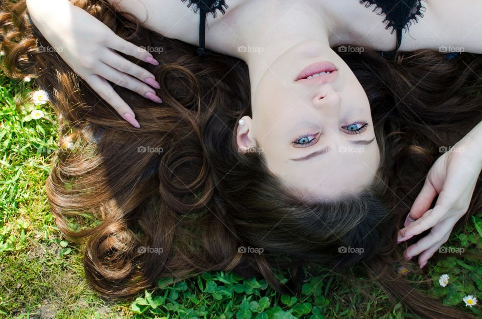 Portrait of Beautiful Young Girl on Background of Daisies