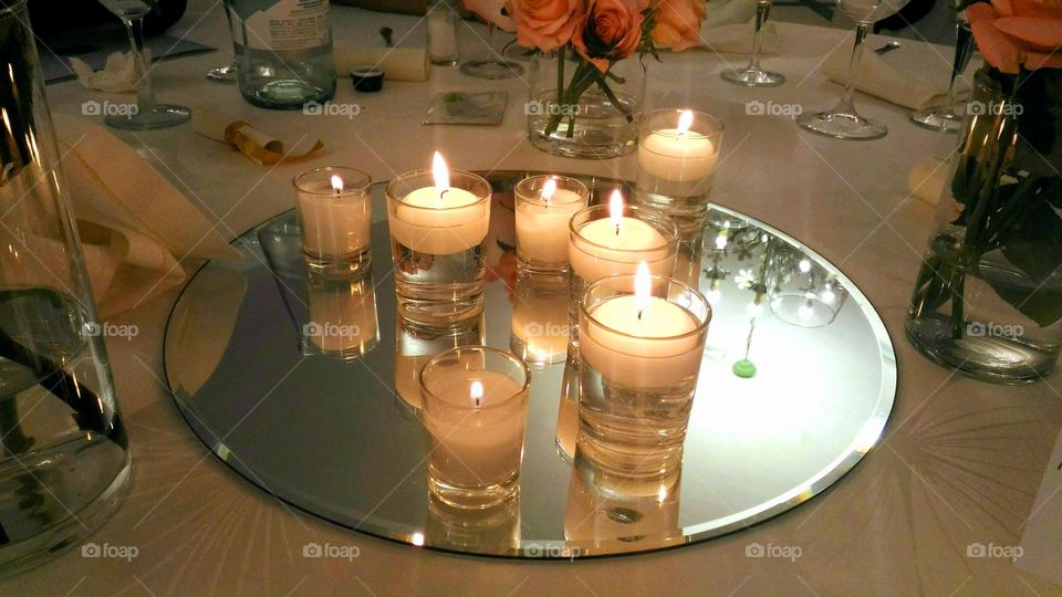 The romantic atmosphere of a set of candles with their soft light on a glass tray