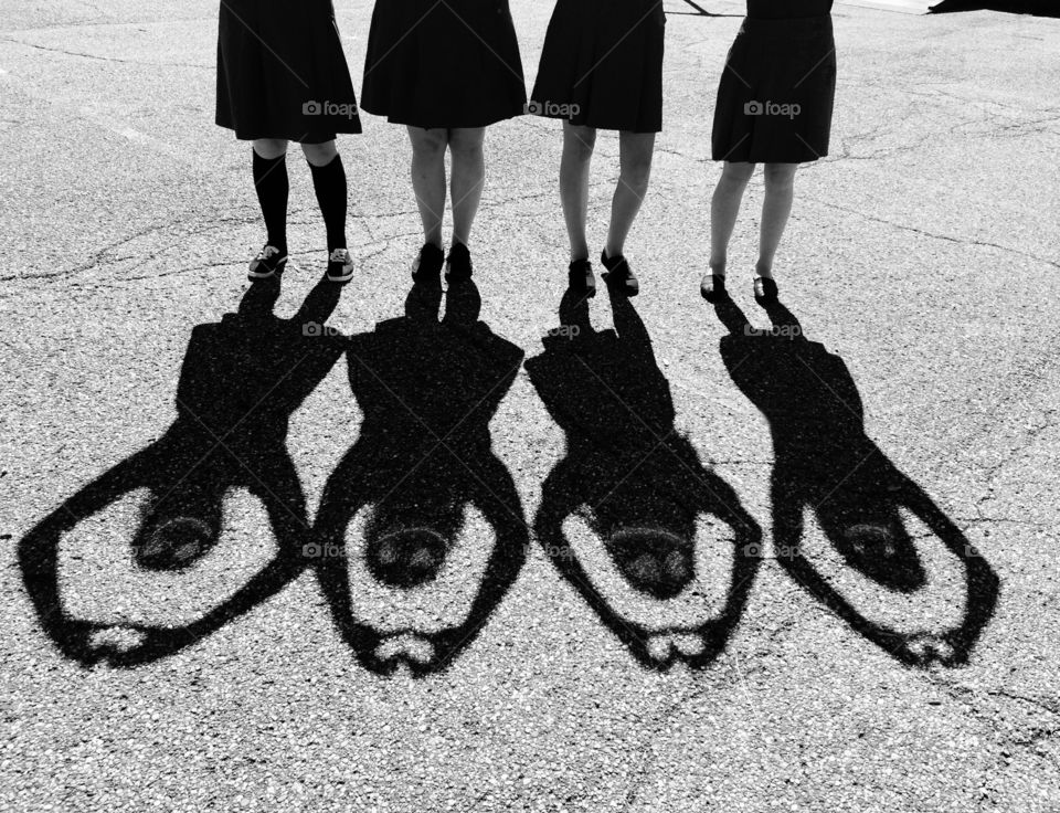 Shadow of girls standing in a row, making a heart symbol with their hands