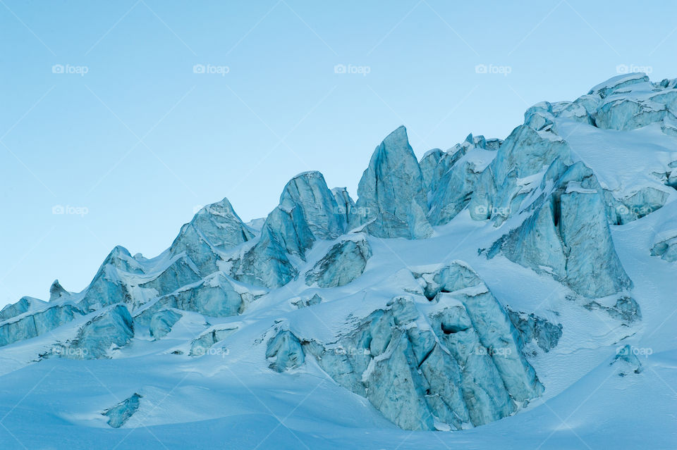 Snowy mountain landscape against blue sky