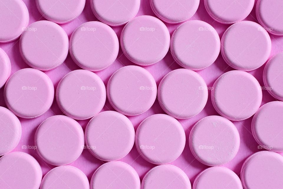 Pink tablets on a pink background 