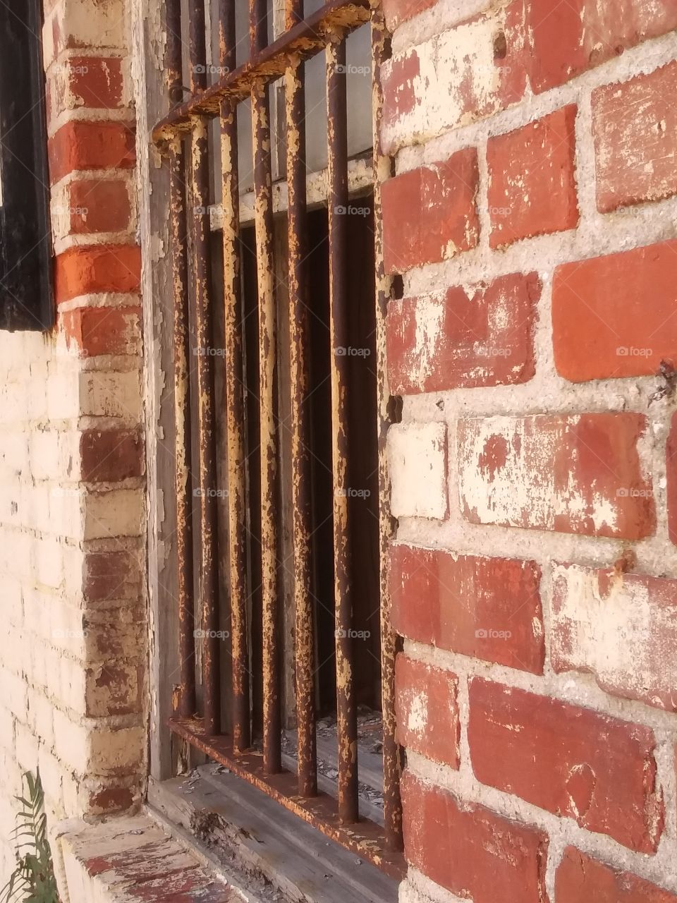 Red Brick Building with Iron Bars in Window