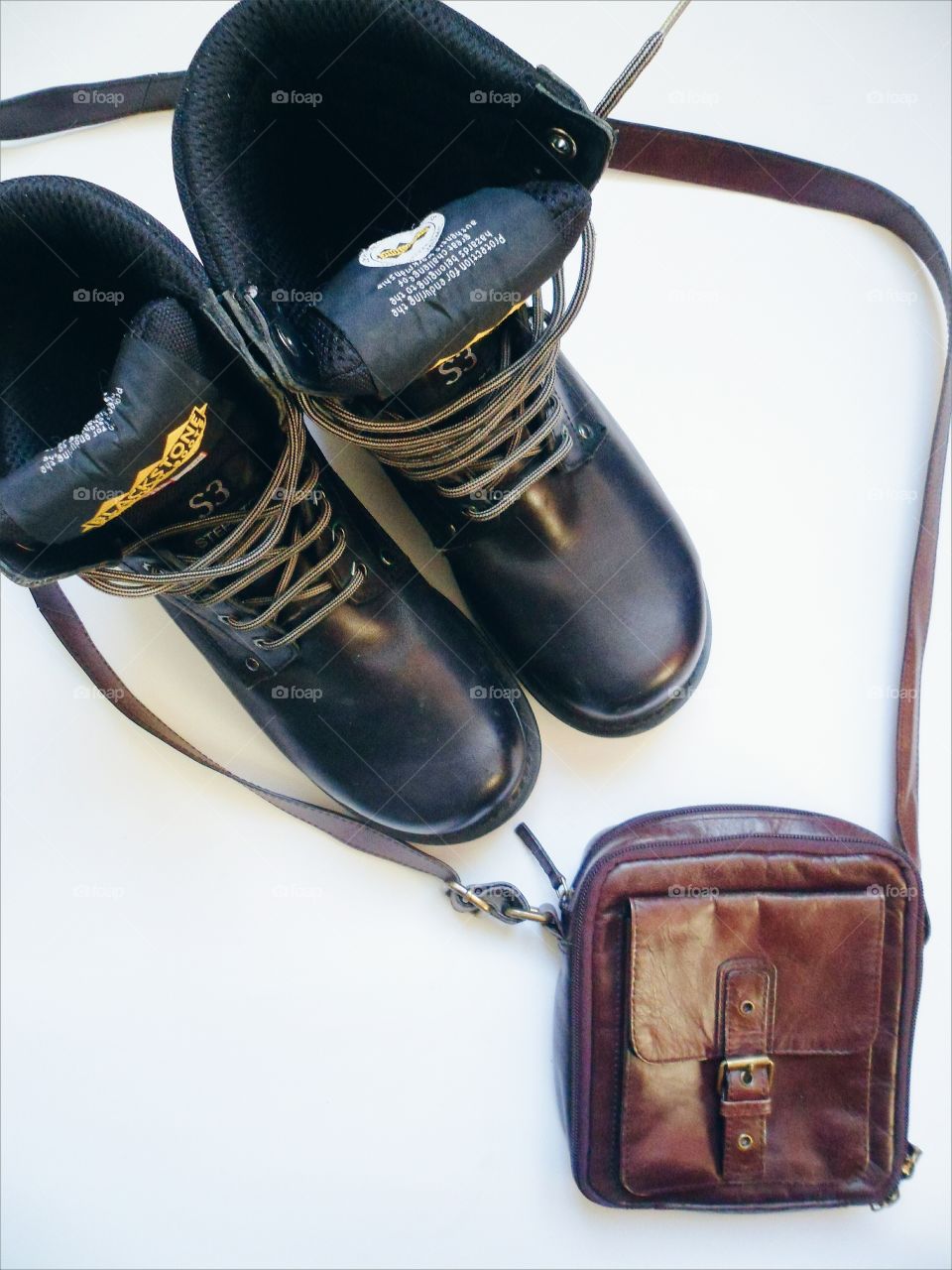 Men's black leather shoes and bag on a white background