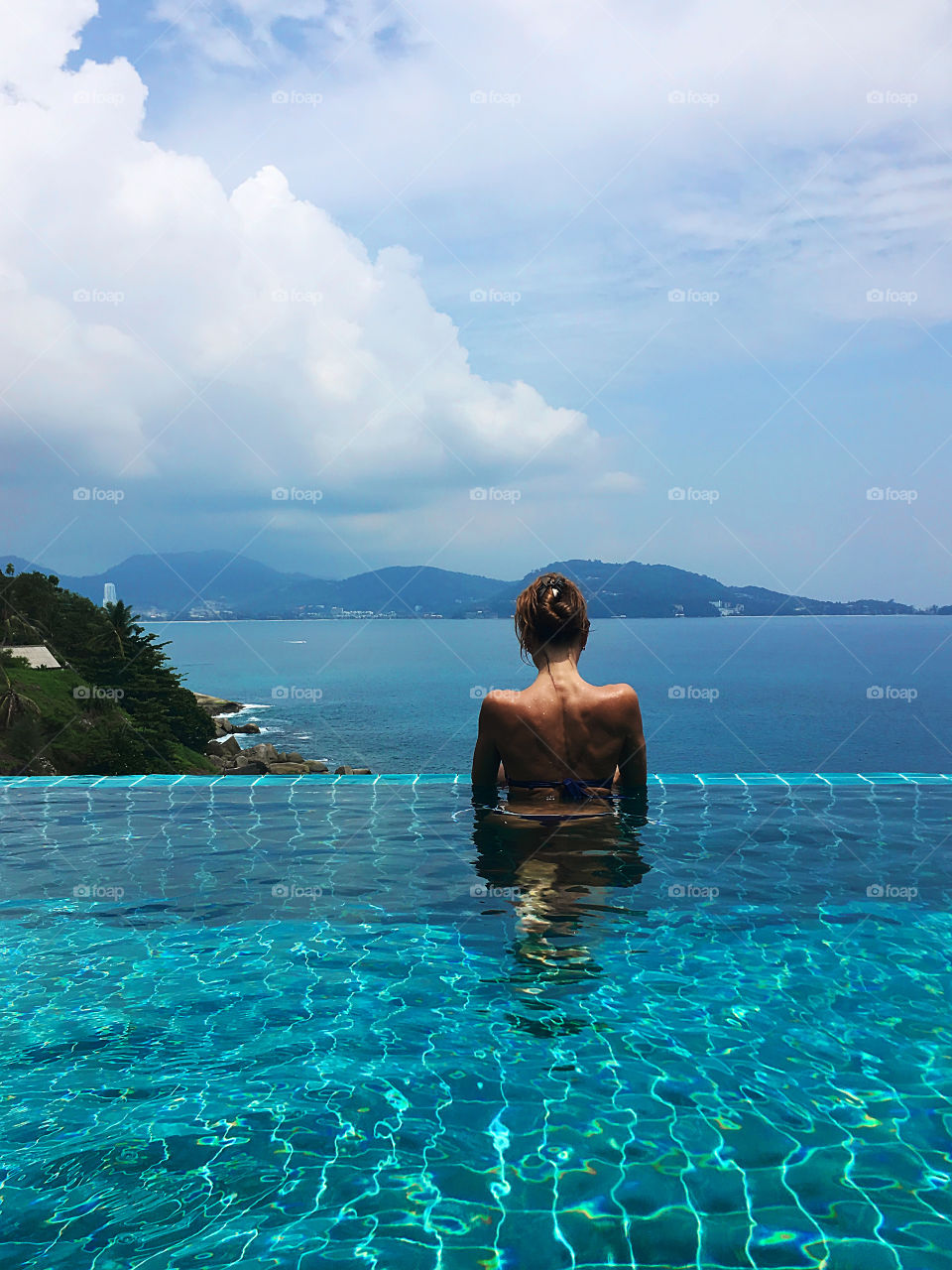 Enjoying the last summer days in the swimming pool above the sea 