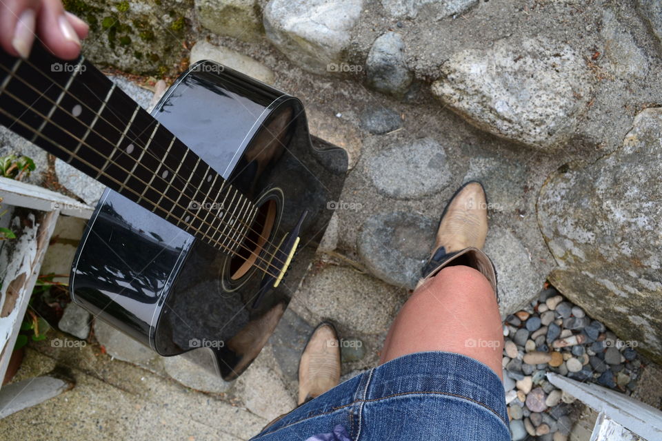 Low section of woman standing with guitar