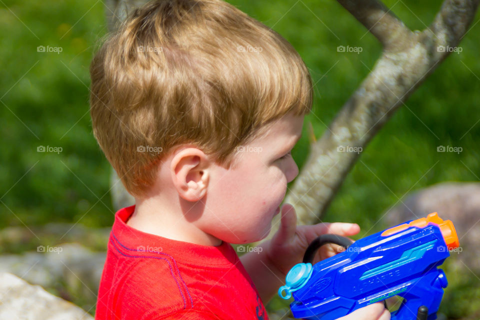 A little boy with plastic water gun