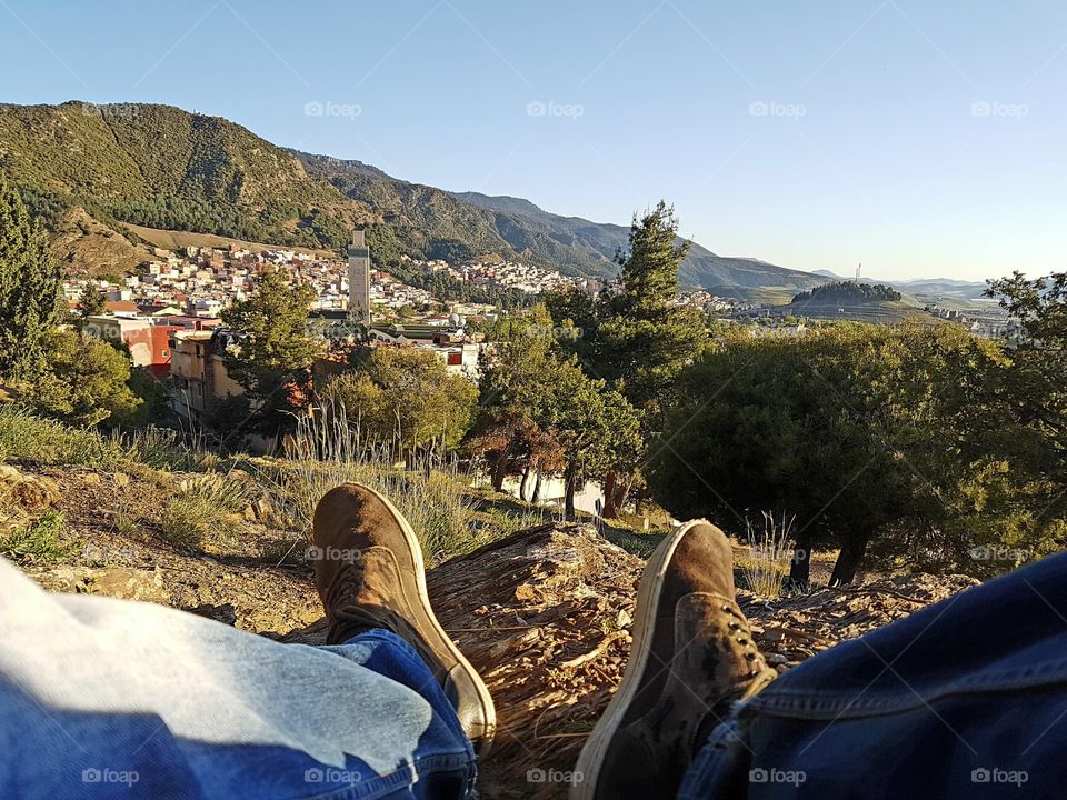 Low section of person sitting on rock