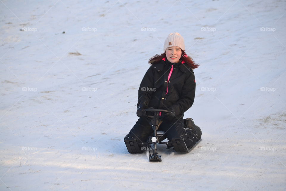 Girl going down the hill in the sled