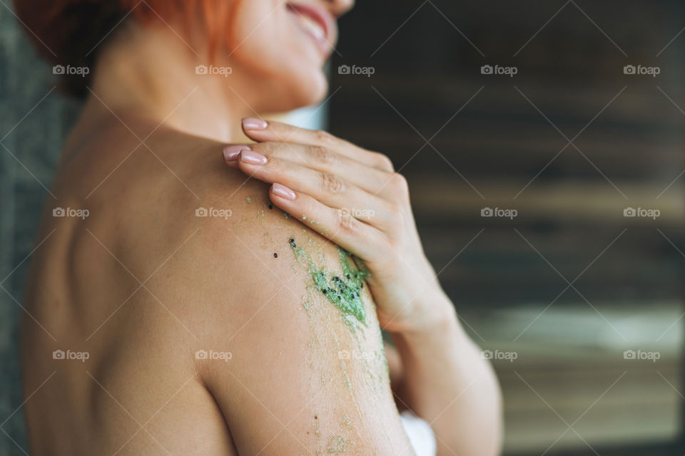 Young woman girl does scrab massage by hands in bathroom spa salon 