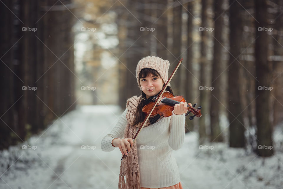 Teenage girl portrait with violin in winter park