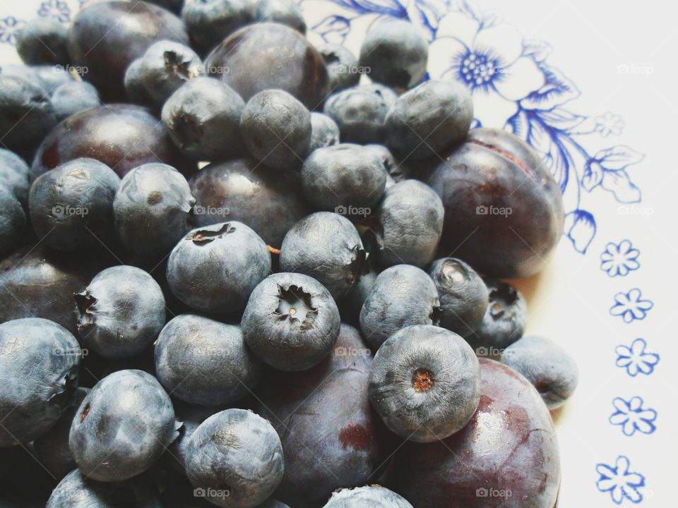 blueberries and plums on a plate