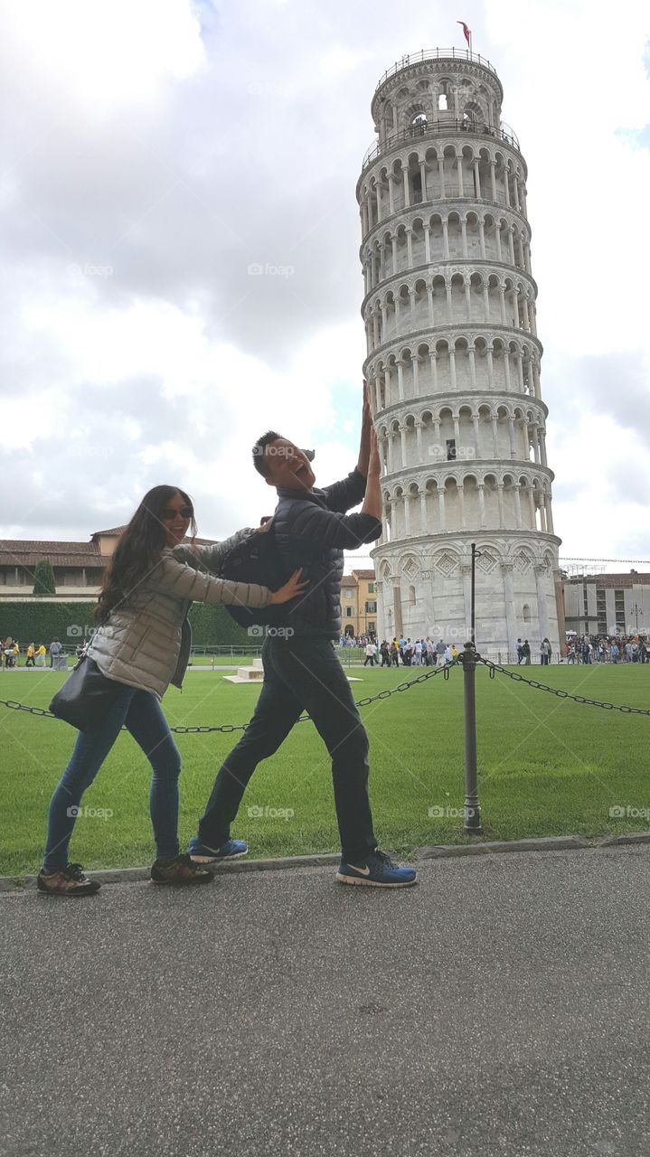 Couple posing at pisa tower, Italy