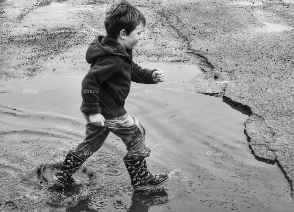 Boy Splashing Through Puddles