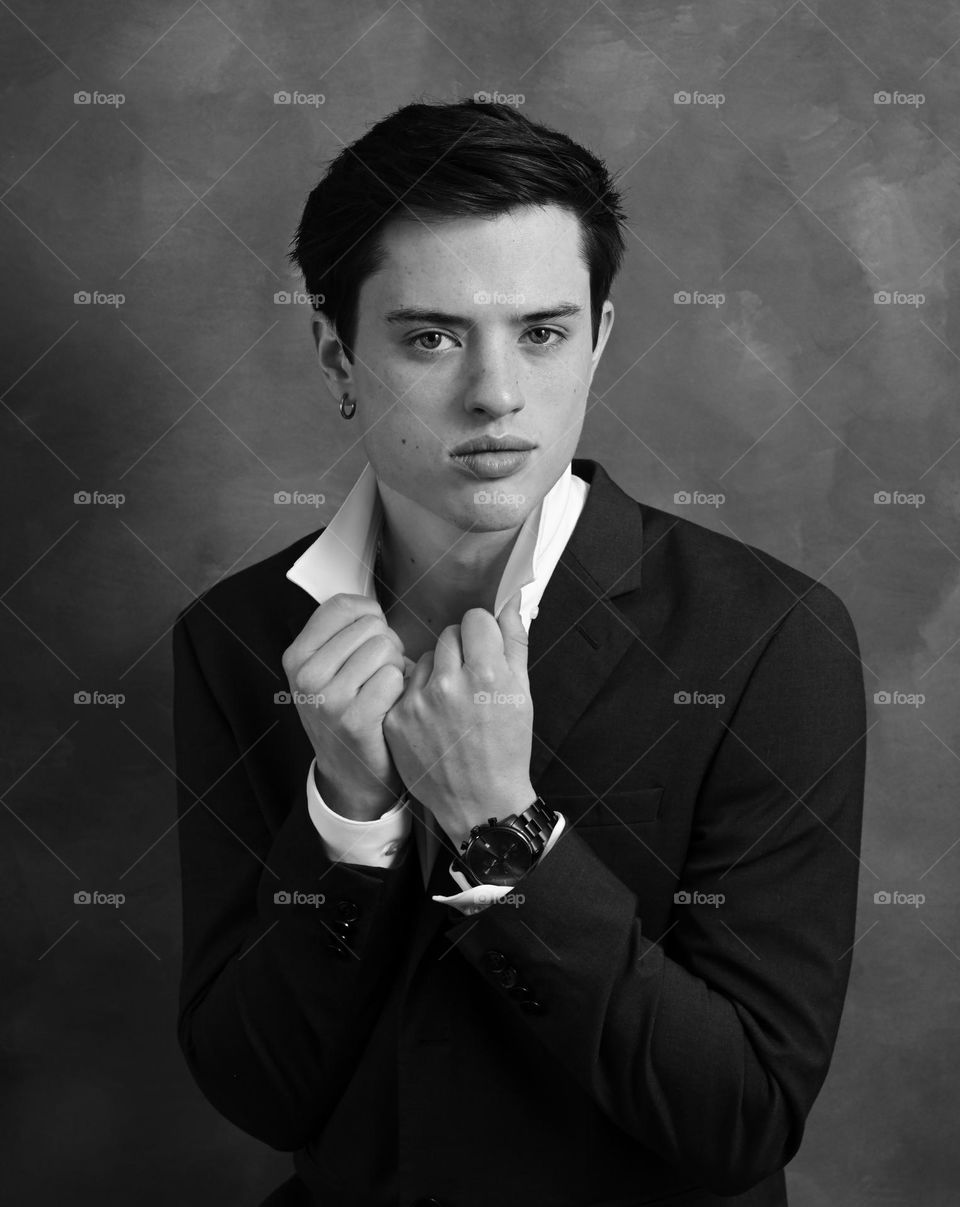 Black and white studio portrait, handsome young man wearing formal attire