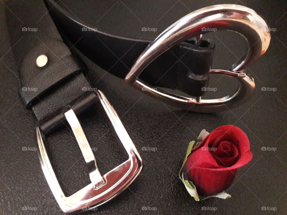 Close-up of belt and red rose