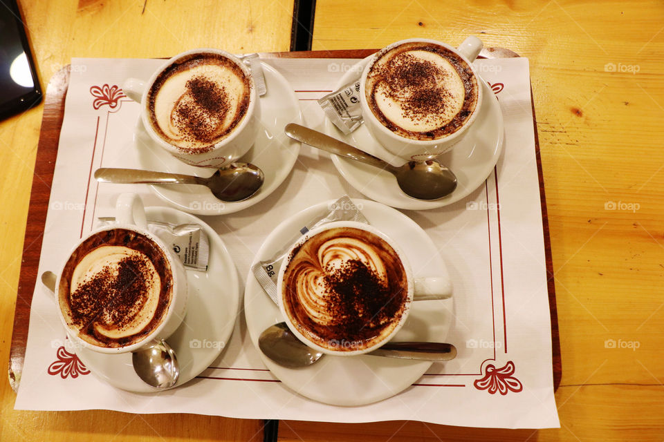 Four cups of mocha coffee nicely arranged on a tray