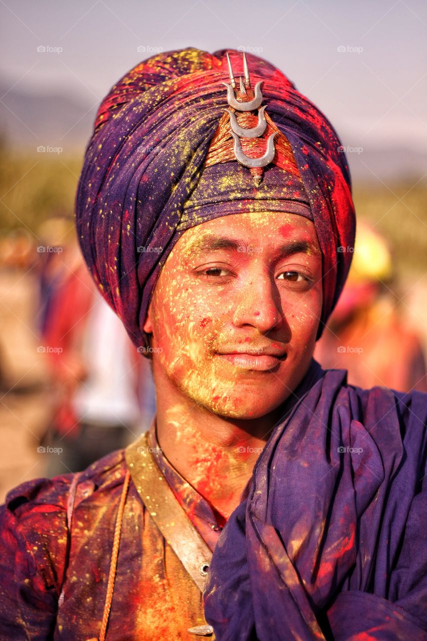 Man in traditional Indian turban smeared with holi colors