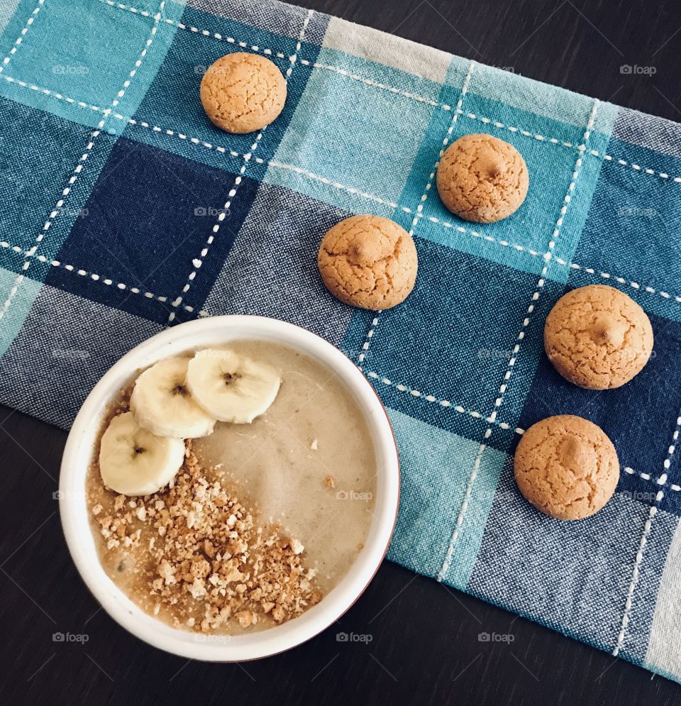 Homemade banana milkshake with crumbled almond biscuits 