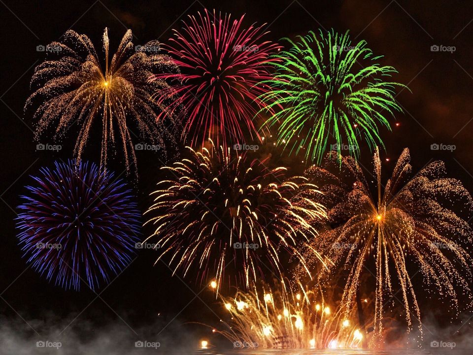 Dazzling multicolored fireworks electrifying the night sky.