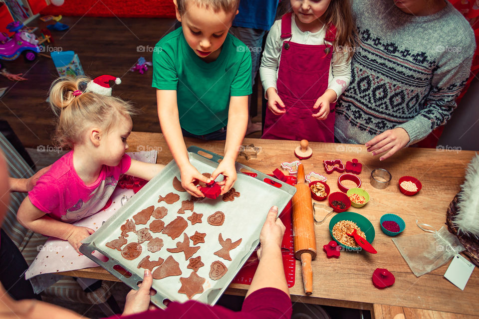 Baking Christmas cookies. Christmas gingerbread cookies in many shapes decorated with colorful frosting, sprinkle, icing, chocolate coating, toppers, put on table. Baking traditional cookies. Family celebrating Christmas. Baking at home