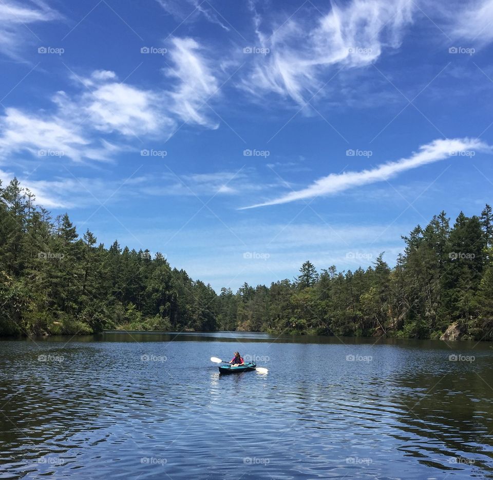 Kayaking in beautiful nature with curving forest and sky 