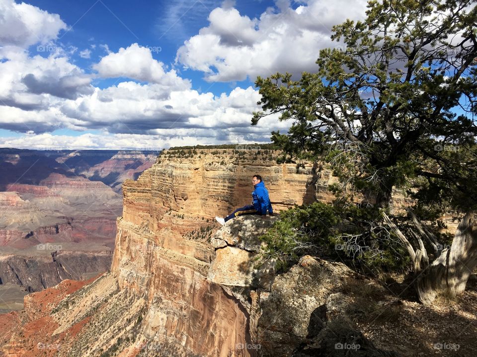 one man seated looking the landscape, the Grand Canyon