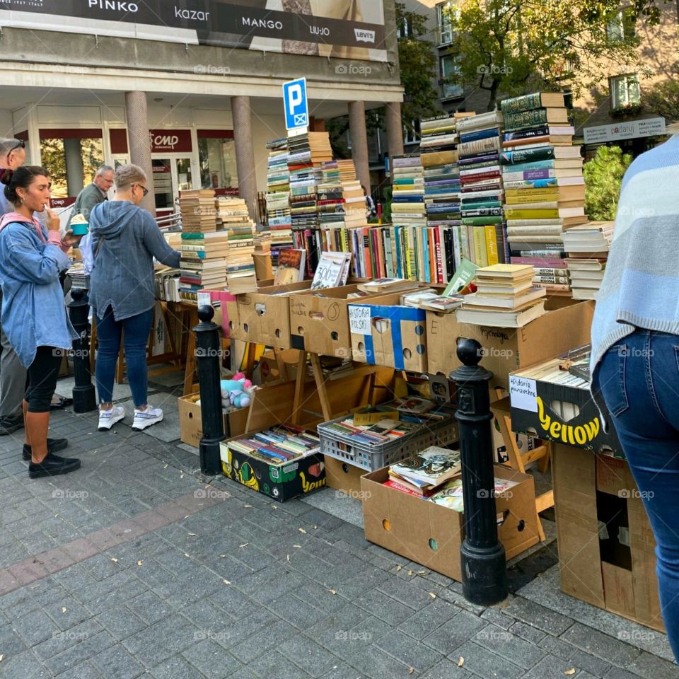 Summer Activities in the USA. Outdoor yard sales including books piled up on a sidewalk sale outside a book store.