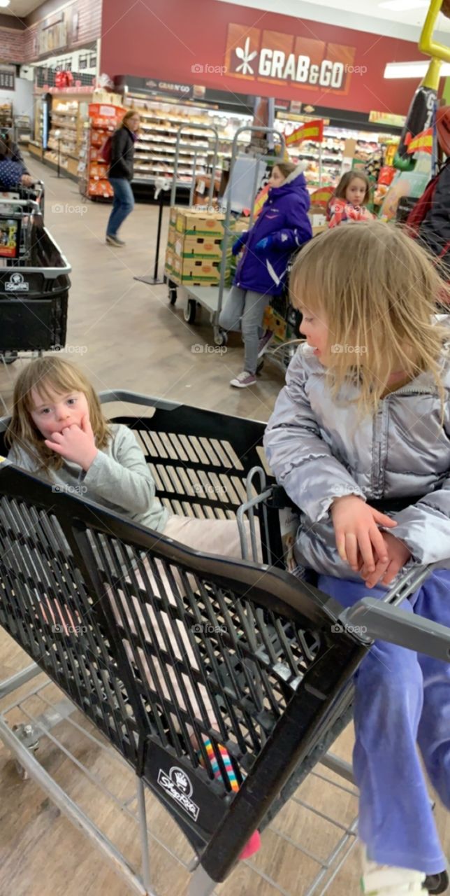 Biological sisters with Down syndrome in shopping cart