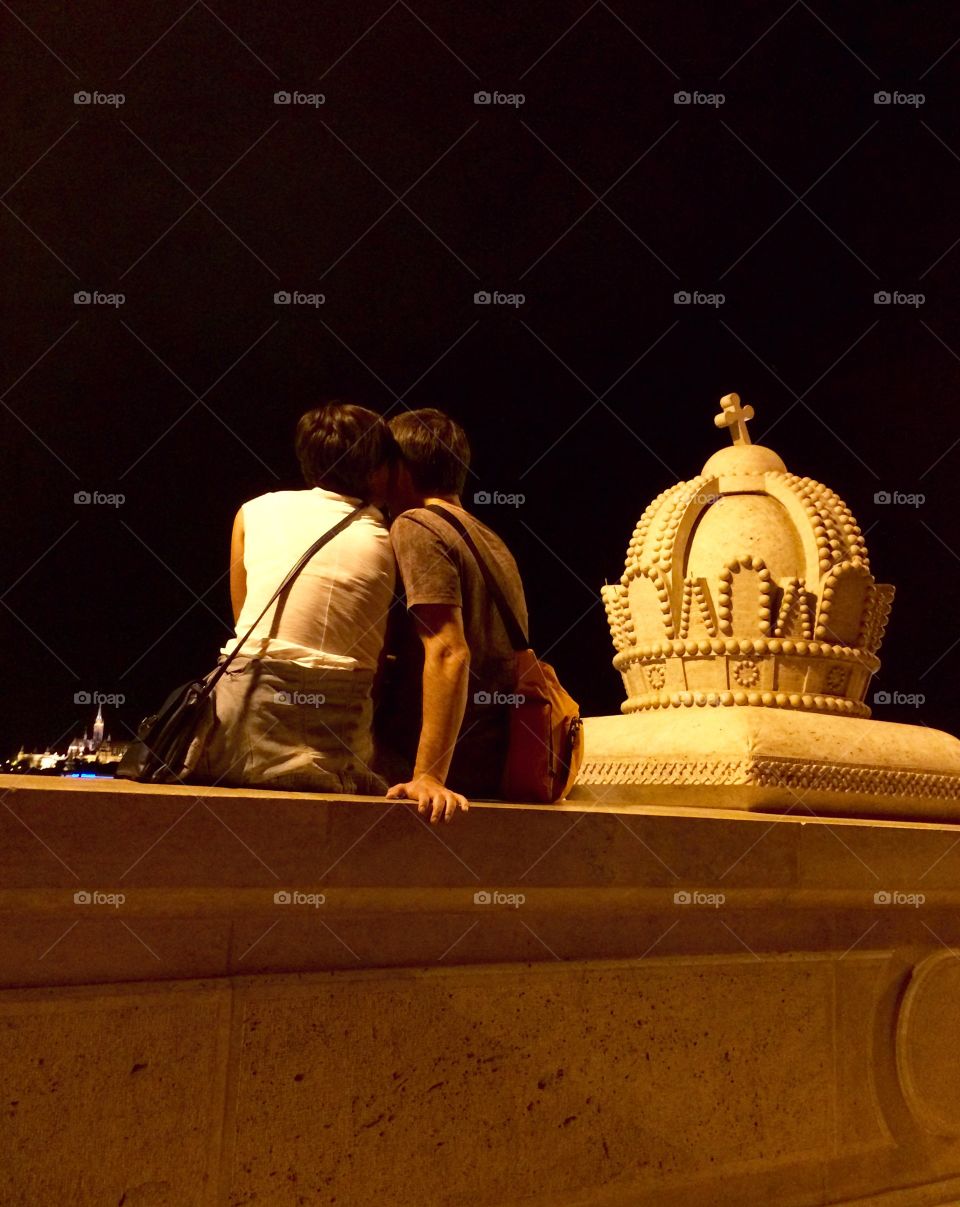 Romance In Budapest. Romantic couple sat on a bridge over the Danube .....