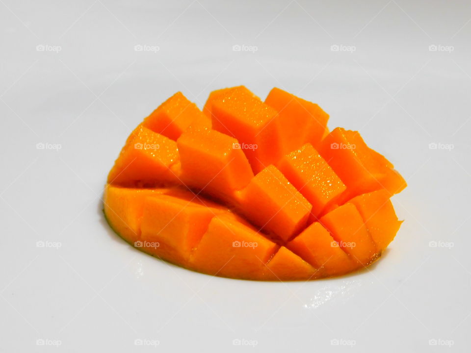Carved mangoes isolated on a white background.Half cut ripen mango having square design with white background.