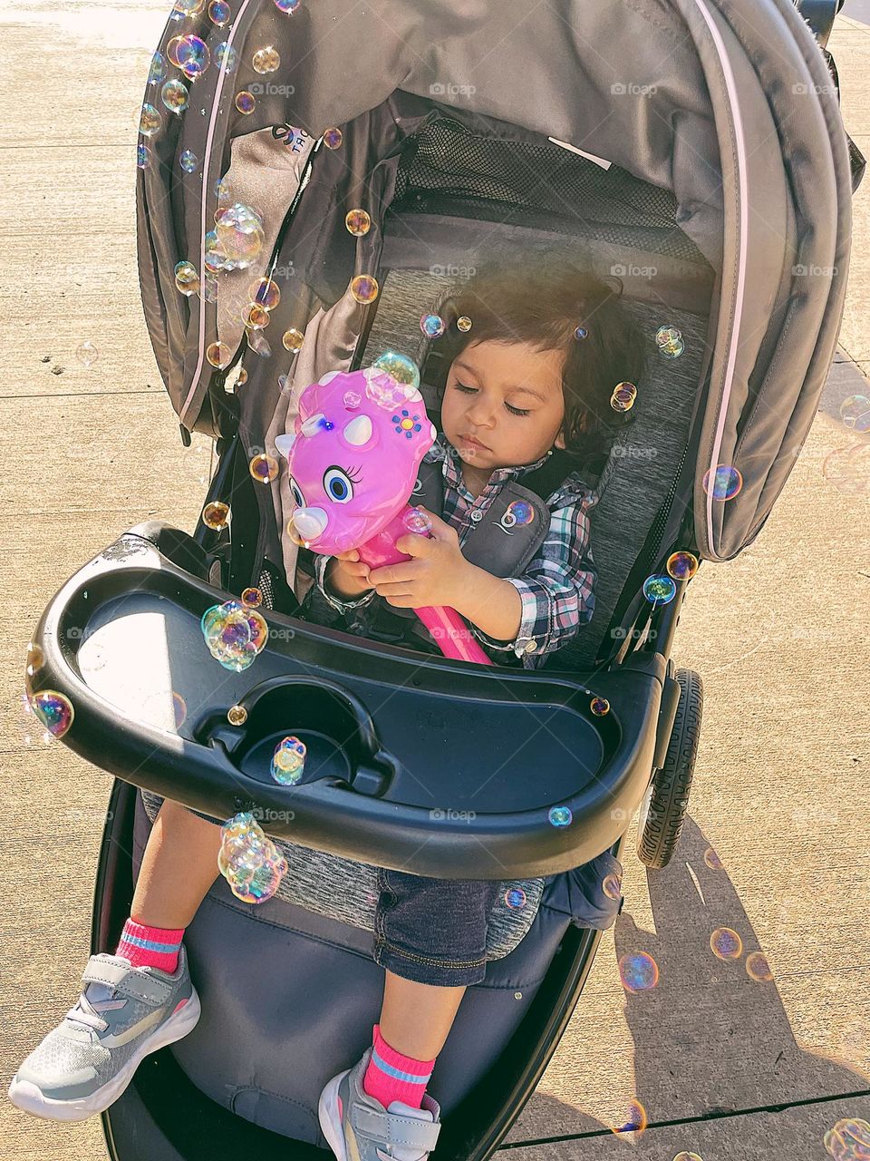 Child in stroller first discovers bubbles, toddler uses a bubble maker at Dollywood, Dollywood Amusement Park with a toddler, moments of happiness with a toddler, fun at amusement parks with children
