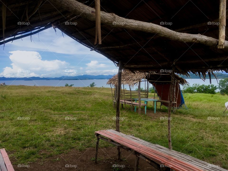 View inside a hut overlooking nature and water.