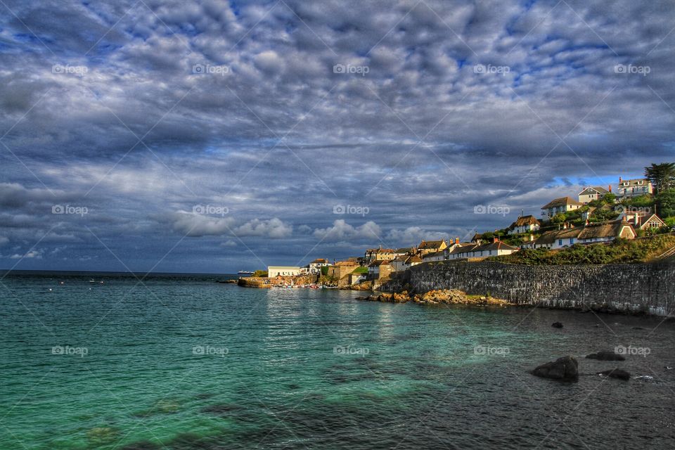 Cornish Fishing Village. A landscape shot of a Cornish fishing village jutting out to sea and lit by the late afternoon sun. 