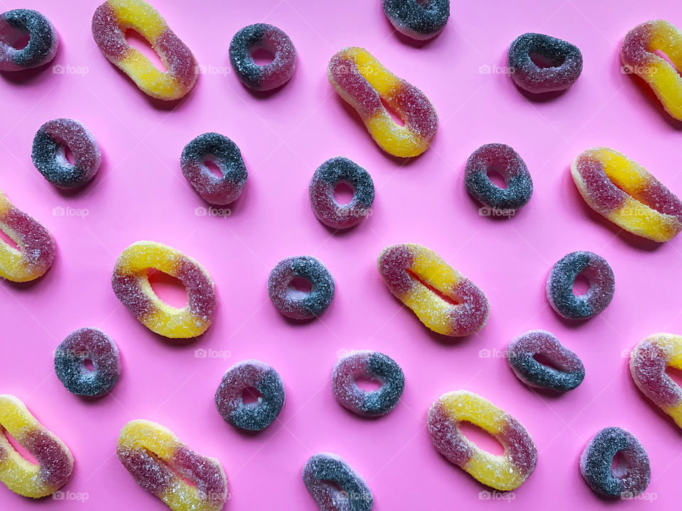 Pattern made of Colorful rubber candies on pink pastel background 