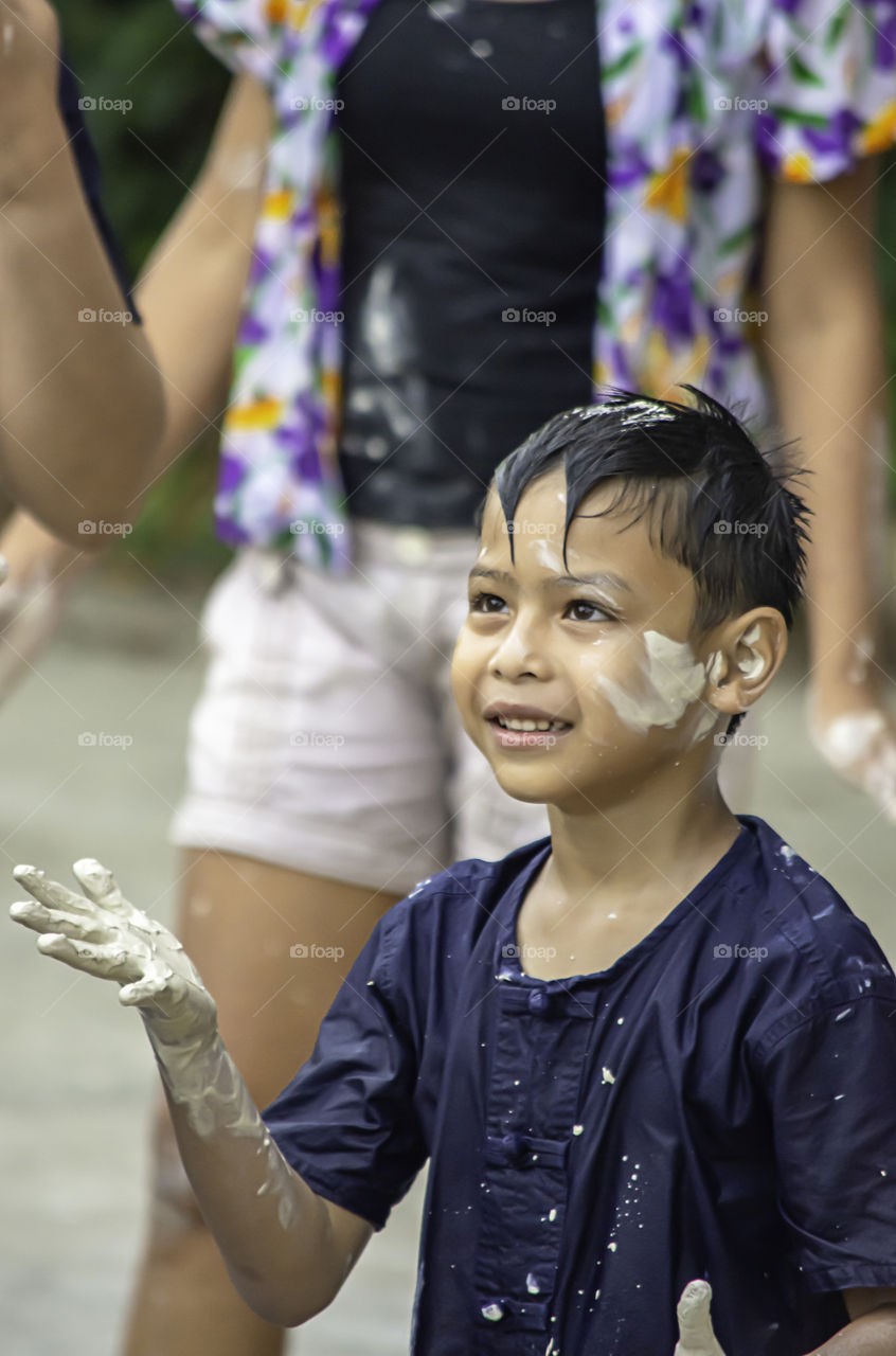 Asian boy play water and flour in Songkran festival or Thai new year in Thailand.