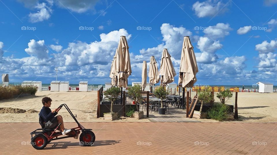 A boy enjoys the last summerdays.  The promenade of De Panne.  Belgium.