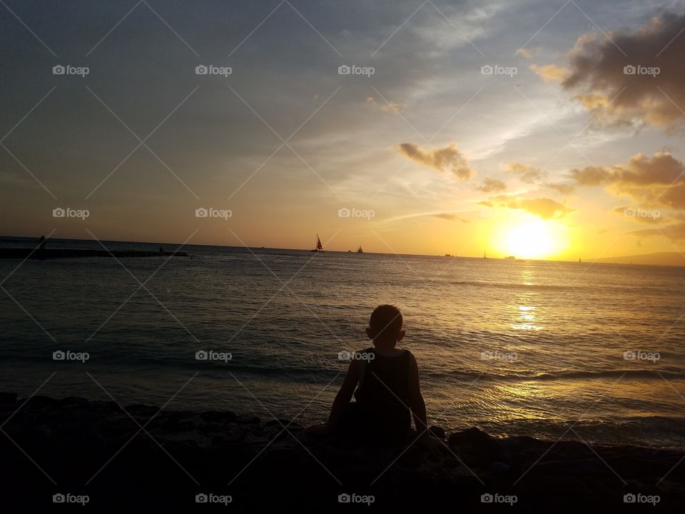 Boy poses before sunset at Waikiki Beach