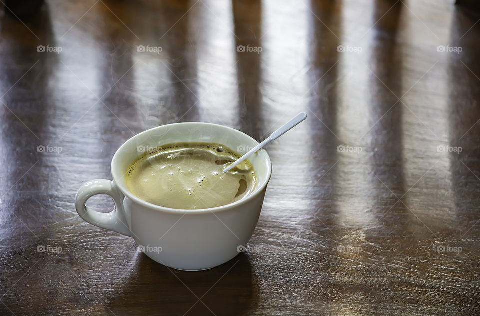 Hot coffee in white glass on wooden table