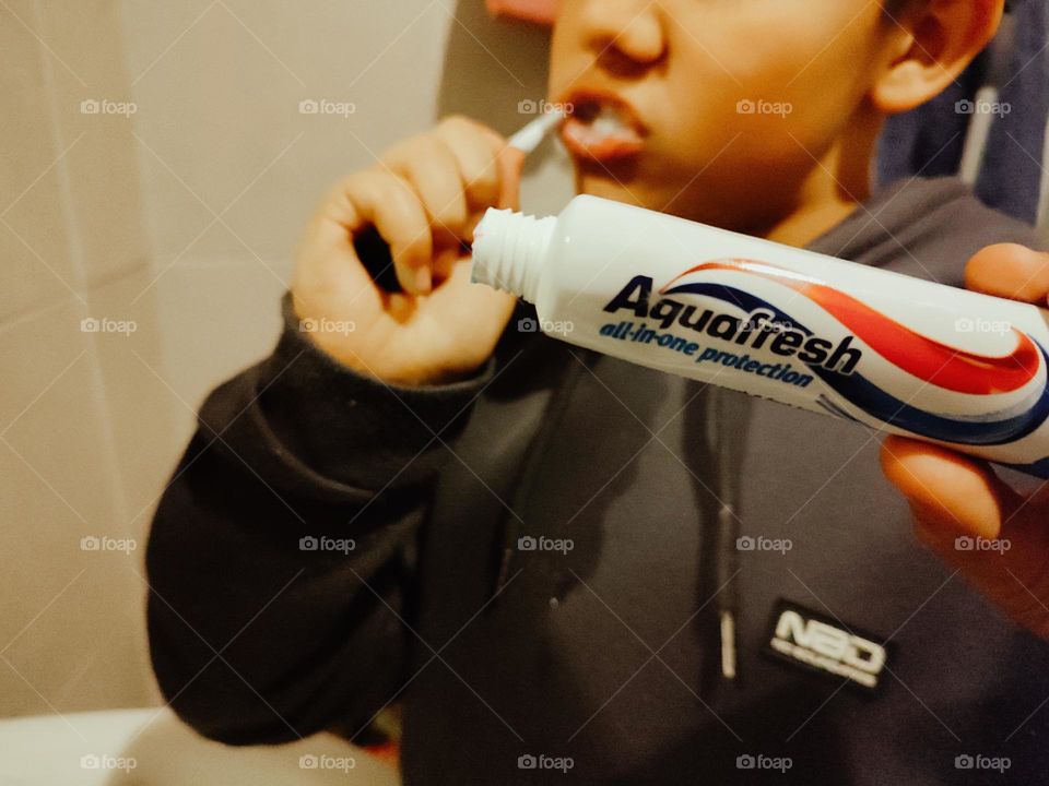 Boy brushing teeth with aquafresh