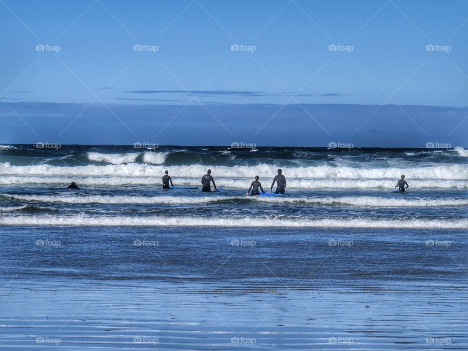 The kids heading out after a quick lesson . Off to catch some surf on a sunny yet blustery day. Good to enjoy the west coast of Vancouver island. Taken at Wickanninish beach Tofino 