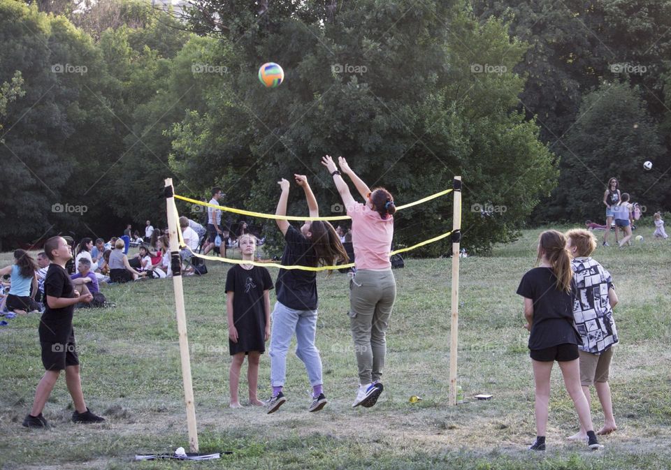 Teens playing volleyball in the park