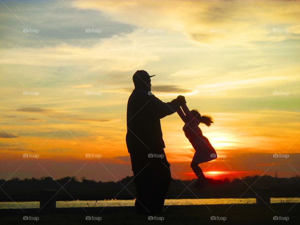 Silhouette of a father and daughter playing 