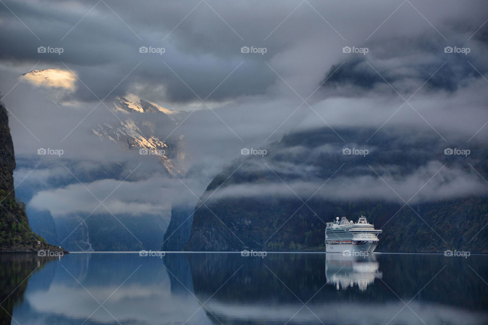 Fog on the fjord. A cruise ship arrives in Aurland's fjord, Norway